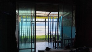 Una habitación con un gran ventanal corredero que da a un balcón con vistas al mar.