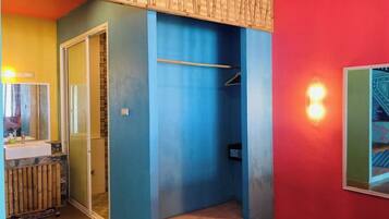 A room with a bathroom, a shower, and a small window.