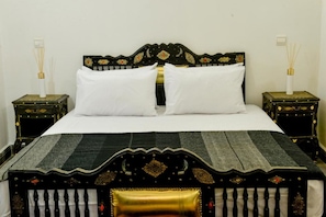 A bed with a decorative headboard, two white pillows, and a striped bedspread. - Casa De Marrakech Riad Guest House (Marrakech)