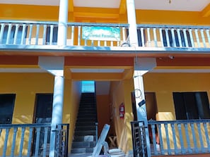 Ein mehrstöckiges Gebäude mit Balkon, Treppe und einem Schild, das 'Argambol Paradise' zeigt.
