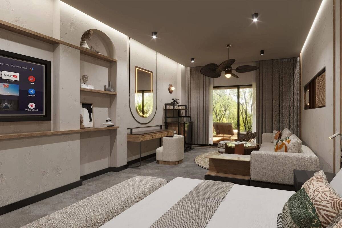 A modern bedroom with a large bed, a seating area, a TV, and a view of the outdoors.