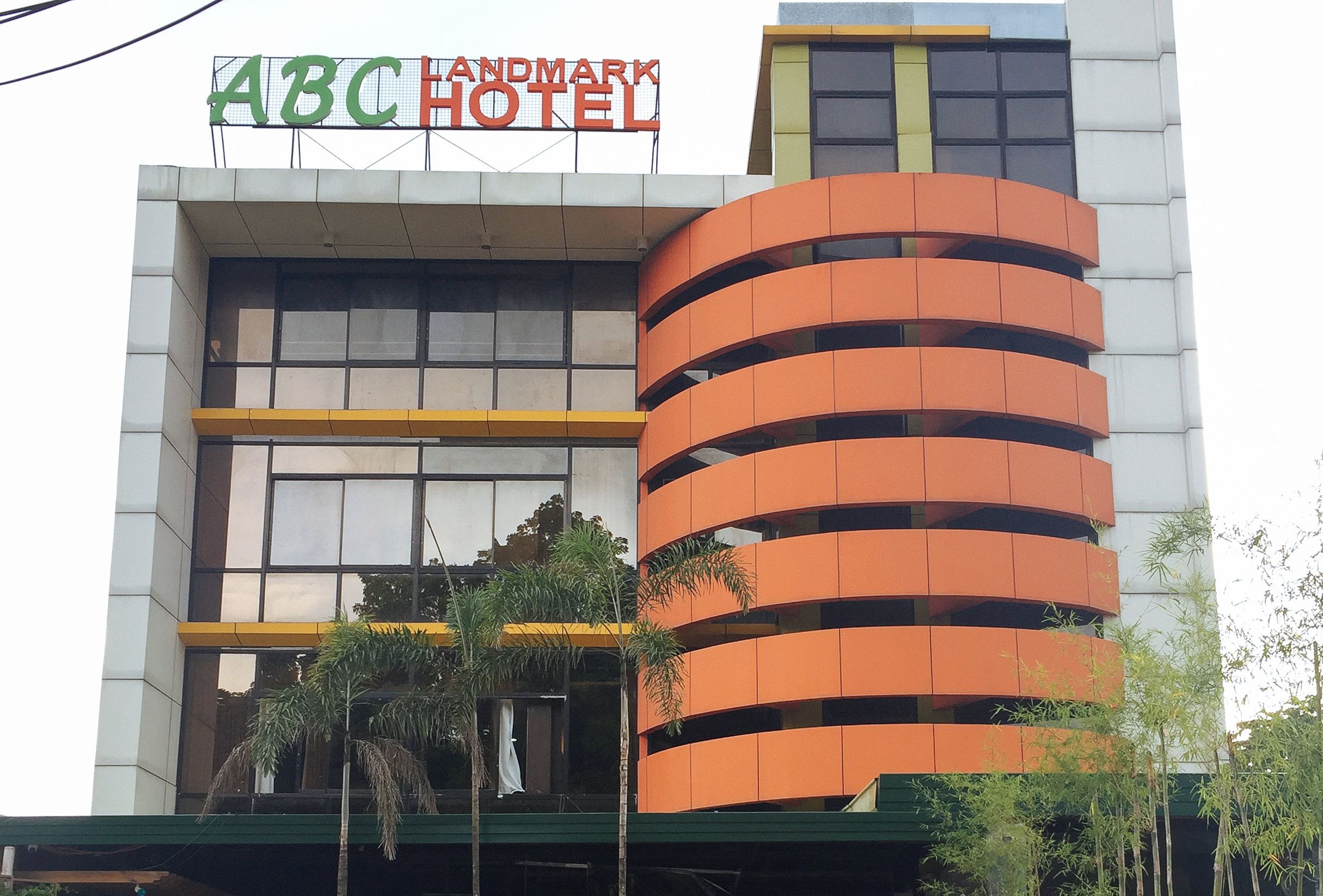 Un hotel con un letrero que dice 'ABC HOTEL' y un diseño arquitectónico moderno con balcones.