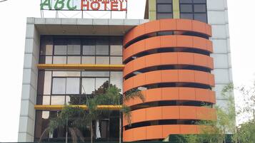 Un hotel con un letrero que dice 'ABC HOTEL' y un diseño arquitectónico moderno con balcones.