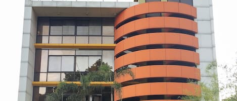 A hotel with a sign reading 'ABC HOTEL' and a modern architectural design with balconies.