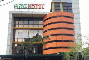A hotel with a sign reading 'ABC HOTEL' and a modern architectural design with balconies. - Reddoorz Plus @ Abc Landmark Hotel (Makilala)