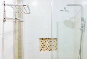 A shower area with a glass door, a metal towel rack, and a showerhead. - Reddoorz Plus @ Abc Landmark Hotel (Makilala)