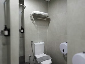A modern bathroom with a toilet, a shower, and a towel rack.