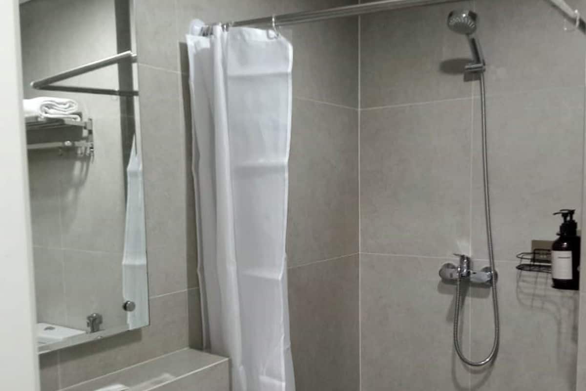 A modern bathroom with a shower, a sink, and a mirror.