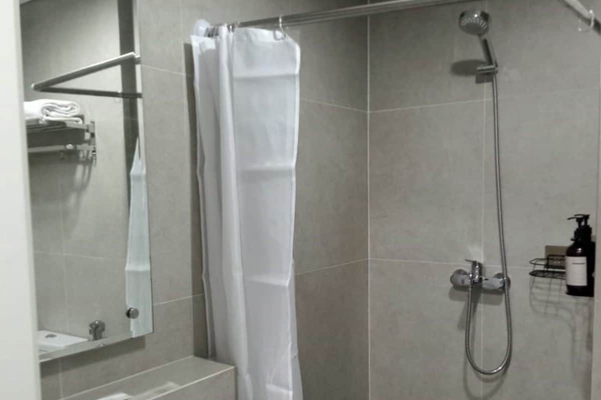 A modern bathroom with a shower, a sink, and a mirror.