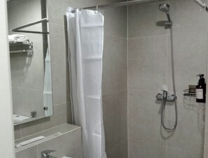A modern bathroom with a shower, a sink, and a mirror.