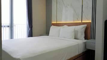 A modern hotel room with a large bed, a wooden headboard, and a marble accent wall.