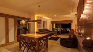 A modern living space with a dining area, sofa, and a view of the outdoors. - Epicenter Lodgings (Ponta Delgada)