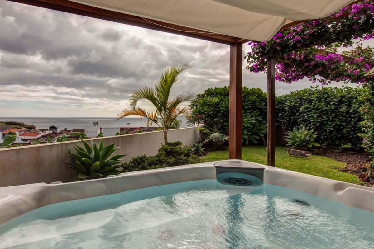 Un jacuzzi con vista al mar y un jardín.