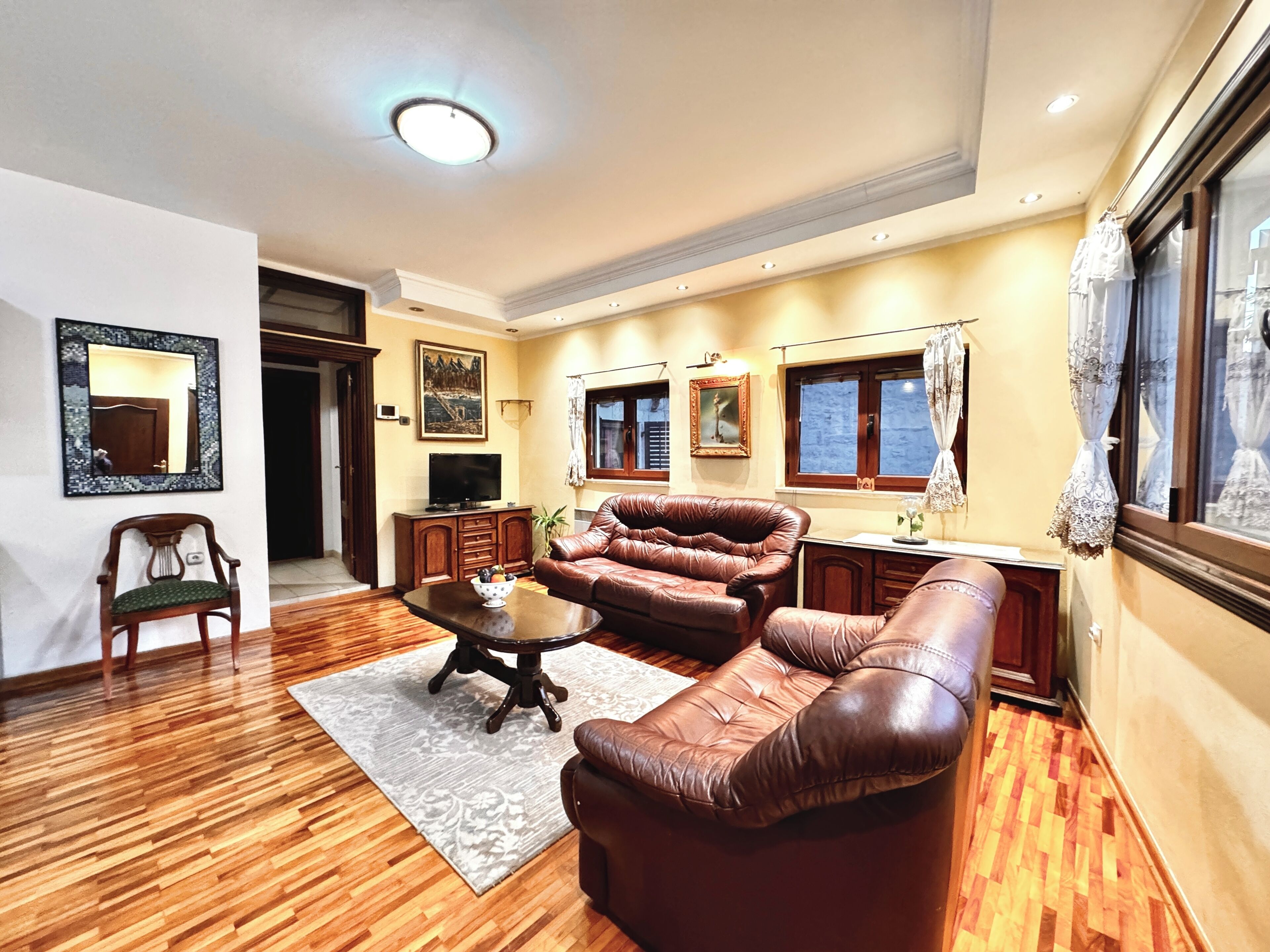 A living room with a sofa, coffee table, and a television.
