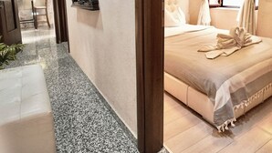 Ein Hotelzimmer mit Bett, Spiegel, Stuhl und kleinem Tisch.
