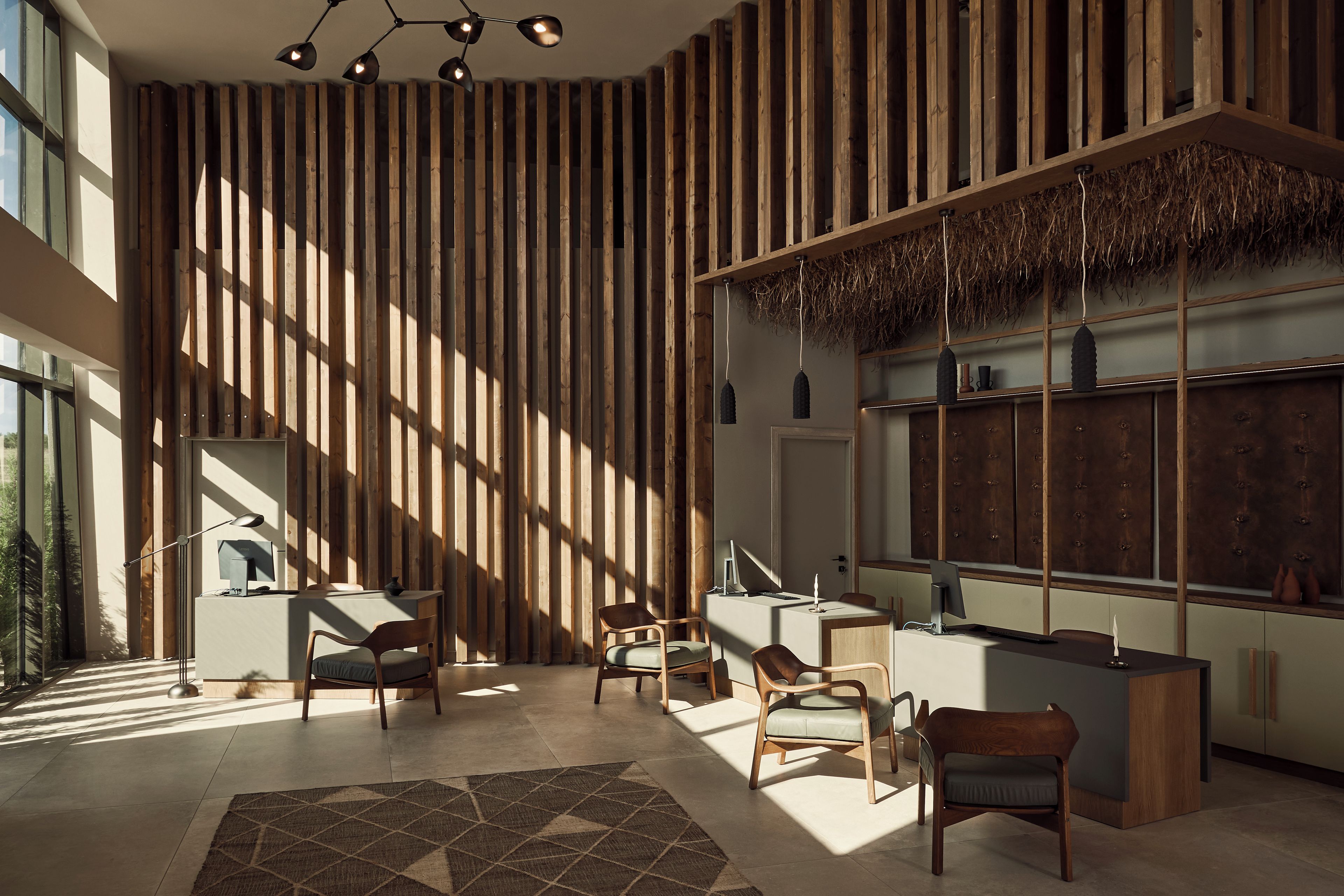A modern interior with a reception desk, seating area, and large windows allowing natural light.