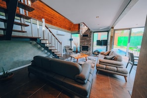 A modern living room with a staircase, a fireplace, and a view of the outdoors. - Daylight Sapanca (Sapanca)
