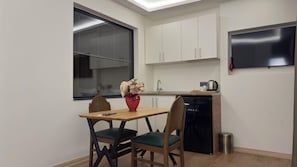 A compact kitchen with a dining area, a window, and a built-in TV. - Lokka Hotel Ortakoy (Istanbul)