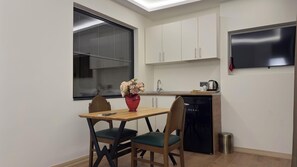 A compact kitchen with a dining area, a window, and a built-in TV. - Lokka Hotel Ortakoy (Istanbul)
