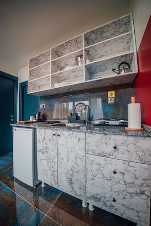 A kitchen with marble cabinets, a built-in shelf, a gas stove, and a sink.