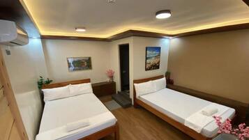 A hotel room with two beds, a painting, a small table with a vase, and a door leading to another room.