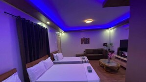 A hotel room with two beds, a sofa, a TV, and a small table with a plant. - Mom Shies Apartelle and Restaurant (Caba)