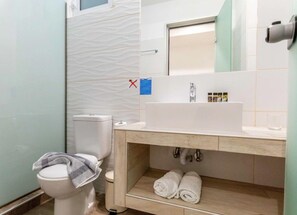 A bathroom with a toilet, sink, and towel rack. - Stay Helios (Rhodes)