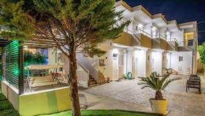 A multi-story building with a covered outdoor area, stairs, and a potted plant. - Stay Helios (Rhodes)
