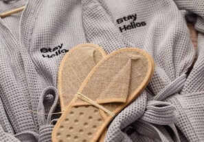 Un par de sandalias con suela trenzada y tejido gris de punto con el texto 'Stay Hello'.