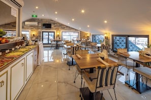 A spacious restaurant with high ceilings, a buffet area, and large windows offering views. - MR. Beyaz Boutique Hotel (Istanbul)