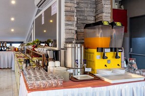 A buffet setup with various food stations, a beverage dispenser, and a coffee machine. - MR. Beyaz Boutique Hotel (Istanbul)