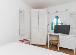 A bedroom with a bed, a desk with a TV, a wardrobe, and a window with curtains. - 5chirpici (Murighiol)
