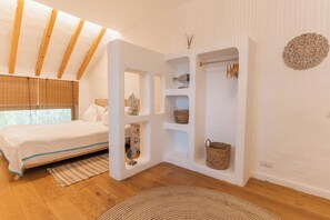 A bedroom with a bed, wooden beams, a built-in shelf with baskets, and a decorative wall piece. - 5chirpici (Murighiol)