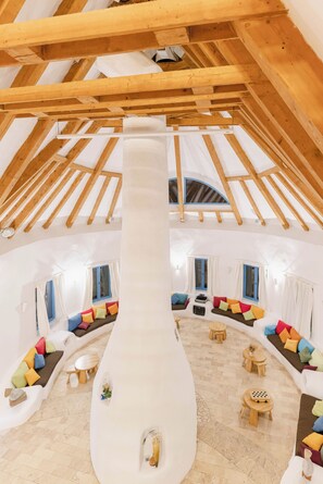 Un loft amplio con techo alto, vigas de madera y un tobogán central.
