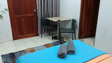 Una habitación con cama, escritorio y dos sillas.