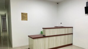 A reception desk in a hallway with a sign on the wall. - Medina House Syariah By Zuzu (Banda Aceh)
