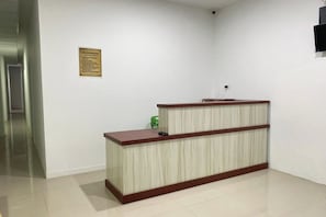 A reception desk in a hallway with a sign on the wall.