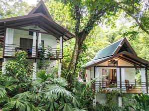 A two-story house with a balcony, surrounded by lush greenery. - Ecotica Boutique Hotel (Quepos)