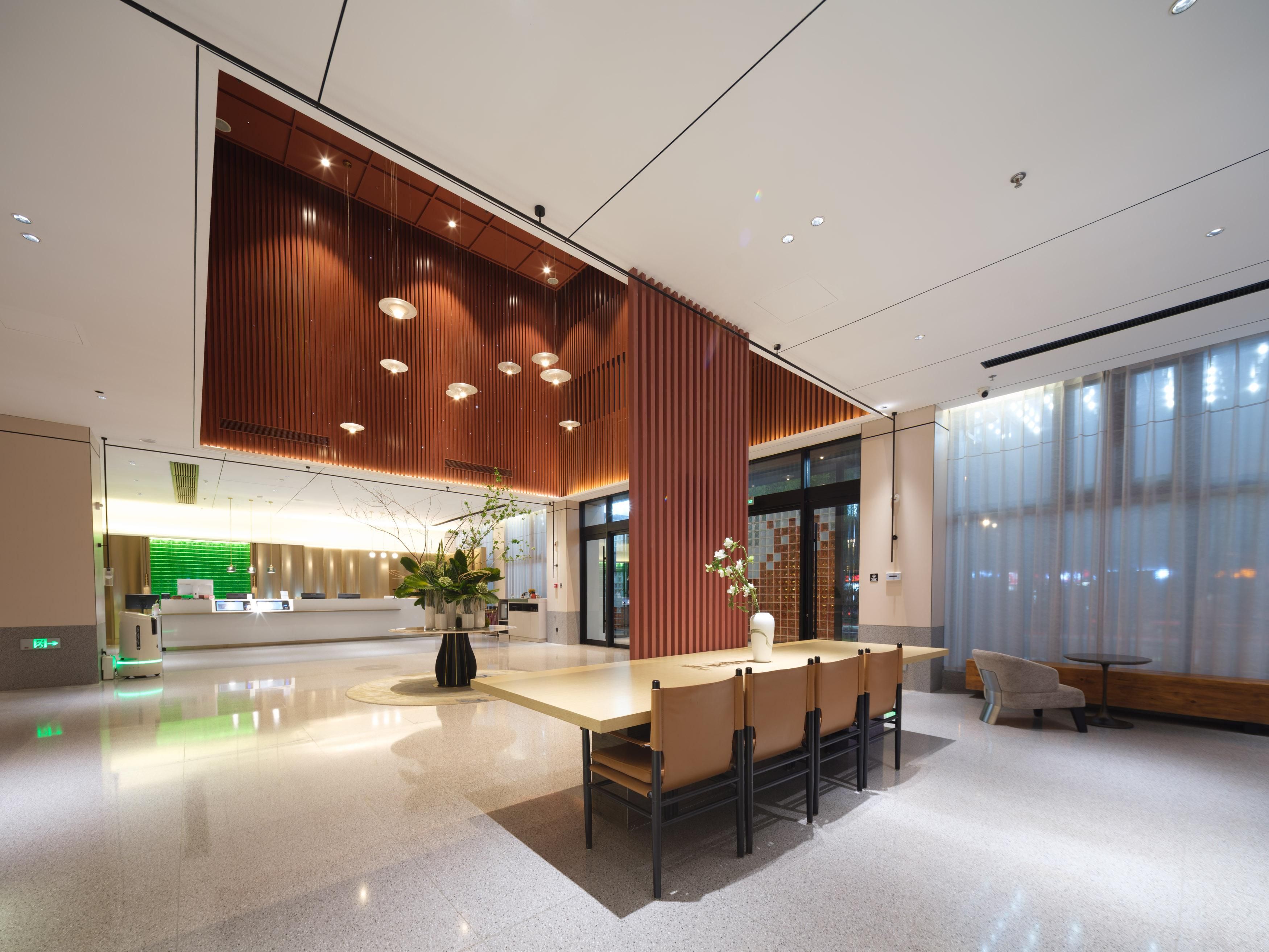 A modern reception area with a reception desk, seating, and a large window.