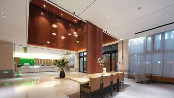 A modern reception area with a reception desk, seating, and a large window.