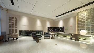 A modern interior with a central seating area, a bookshelf, and a decorative wall.