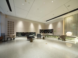 A modern interior with a central seating area, a bookshelf, and a decorative wall.