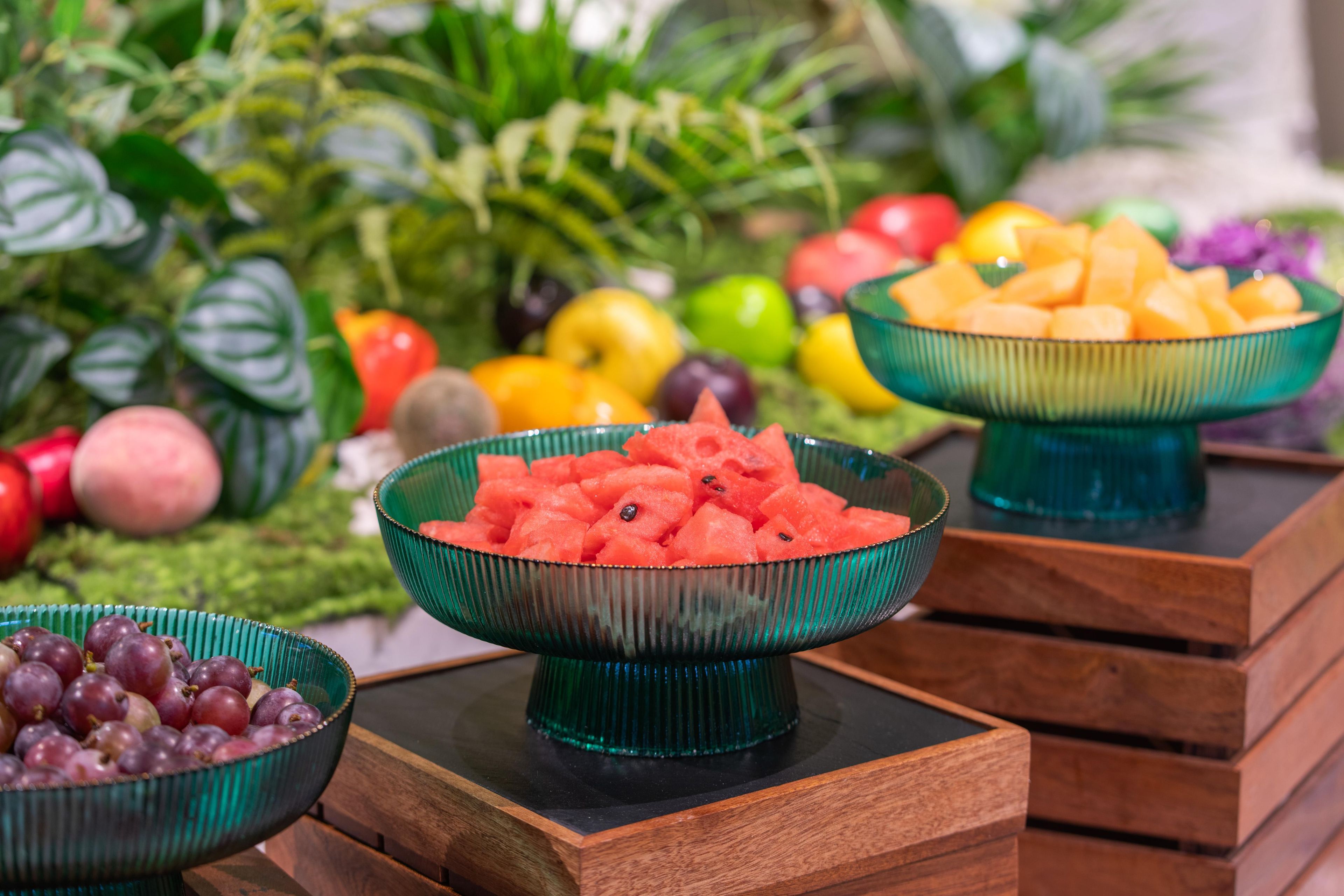 A table with bowls of fruits and vegetables.
