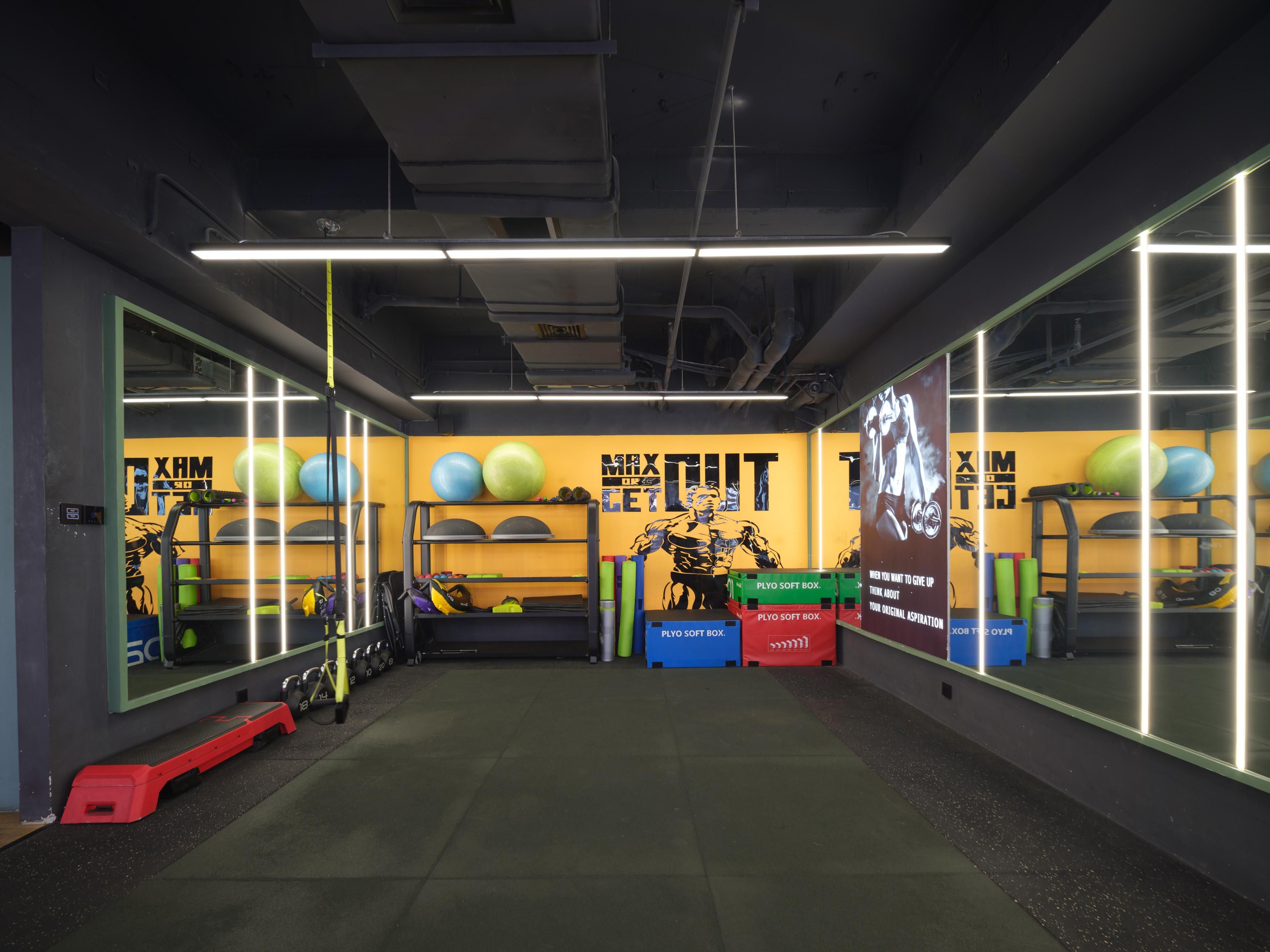 A gym with exercise equipment, a mirrored wall, and motivational posters.