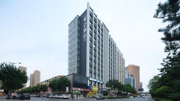 A modern hotel with a prominent vertical facade, multiple floors, and a large entrance.