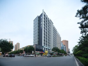 Et moderne hotel med en markant, lodret facade, flere etager og en stor indgang.