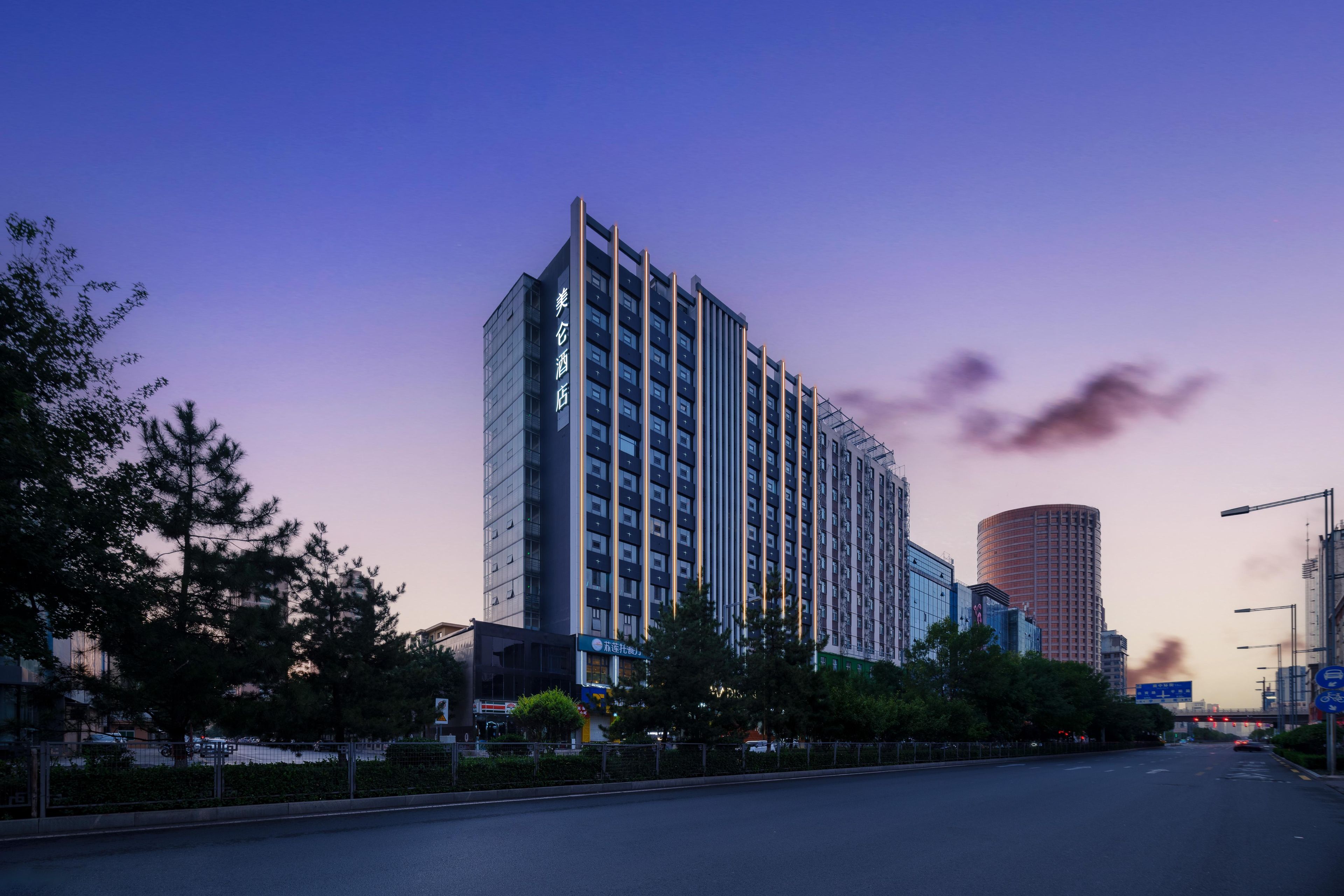 Un hotel de gran altura con varios pisos, diseño arquitectónico moderno y una entrada destacada.