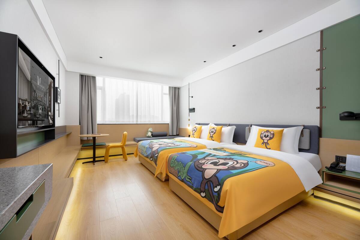 Habitación de hotel con una cama grande, un escritorio, una silla y un televisor.