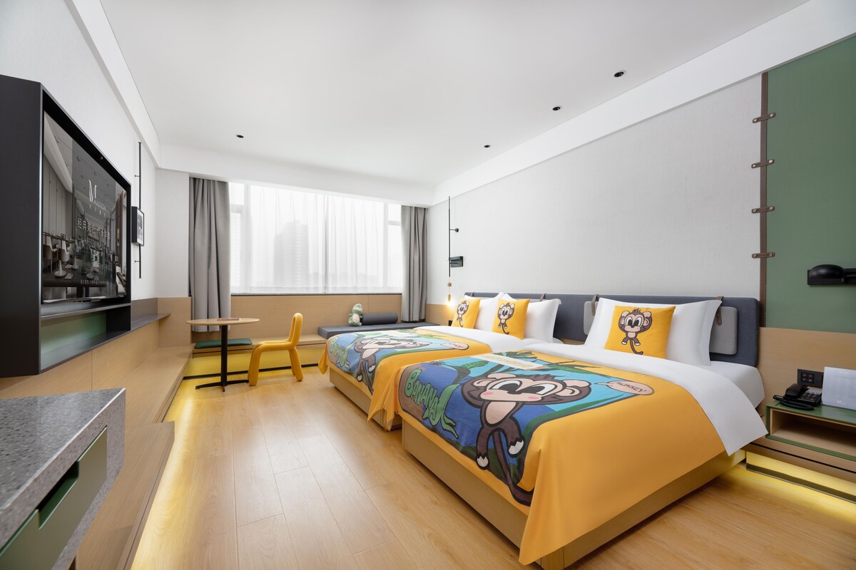 Habitació d'hotel amb un llit gran, una taula de treball, una cadira i una televisió.