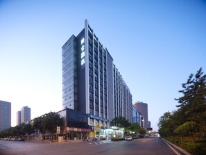 A high-rise building with a modern architectural design, featuring a prominent vertical structure and a series of windows. - Madison Hotel Taiyuan High-tech Zone Xuefu Street (Taiyuan)